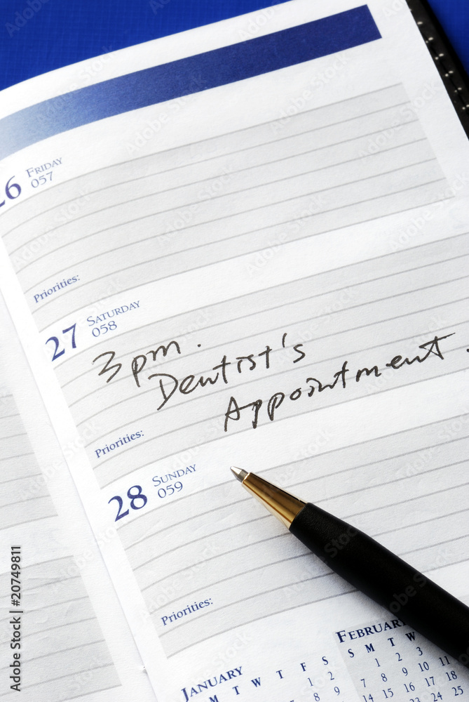 Write down the appointment in a day planner Write down the appointment in a day planner