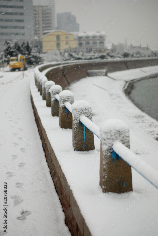 Obraz premium White snow covered the seaside guardrail