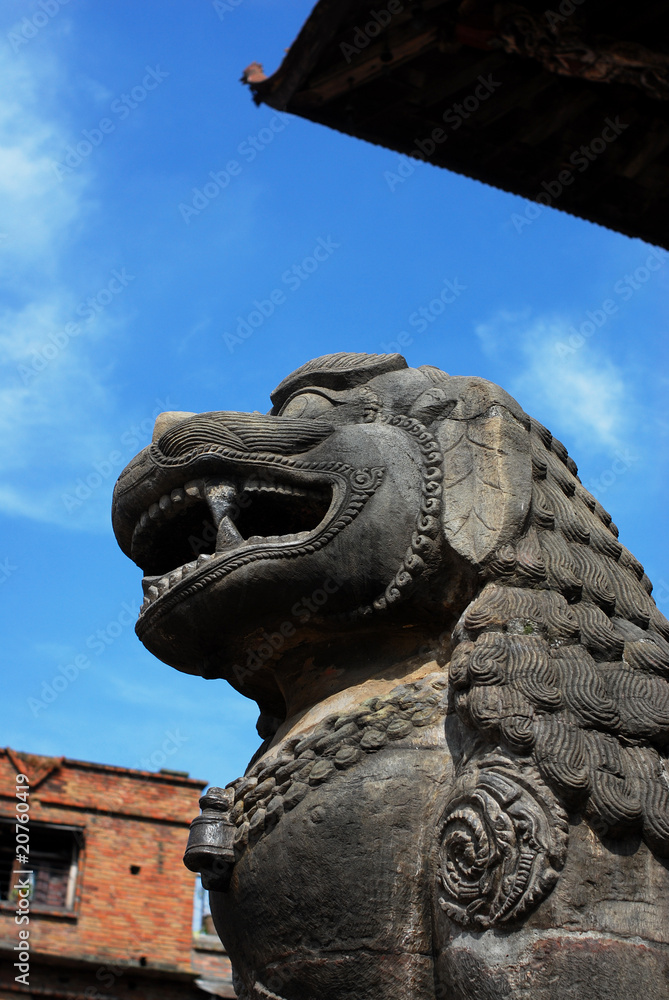 Ancient lion sculpture under blue sky