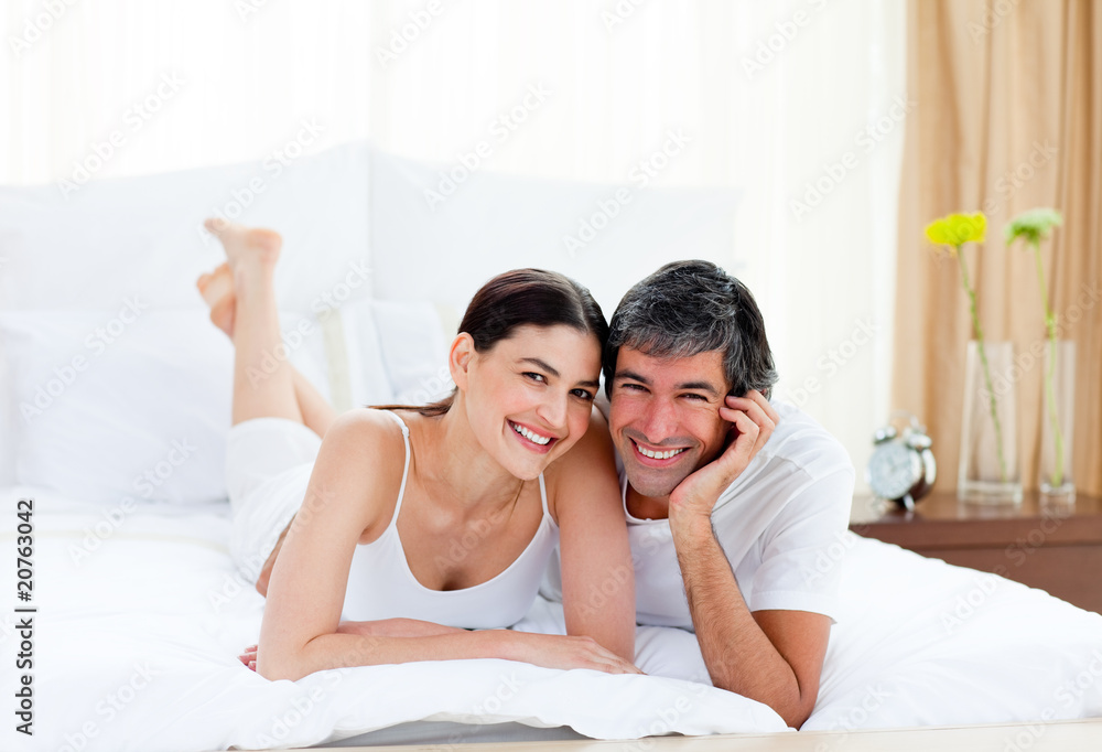 Romantic couple embracing lying on their bed Romantic couple embracing lying on their bed