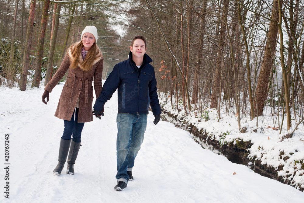 Young couple have a forest winter walk