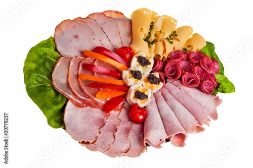 Dish with sliced ham, cheese and salami rolls.