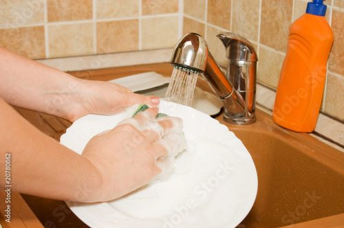 The woman washes ware on kitchen photo