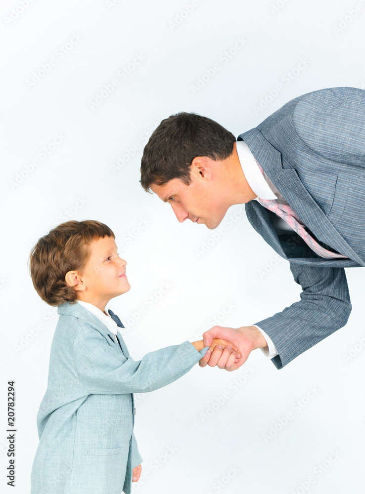 Portrait of smiling man and his son holding by hands Portrait of smiling man and his son holding by hands