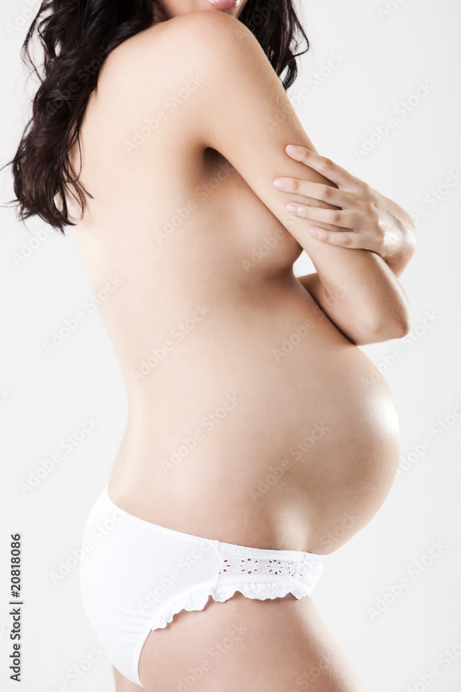 Close up of a nude pregnant body from profile