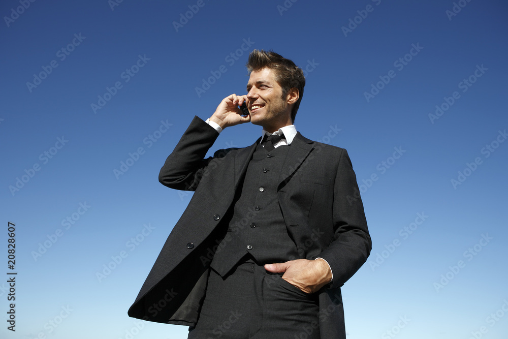 Young businessman in suit on the phone outdoors Young businessman in suit on the phone outdoors