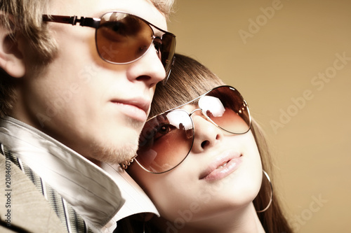 Fashionable young couple wearing sunglasses