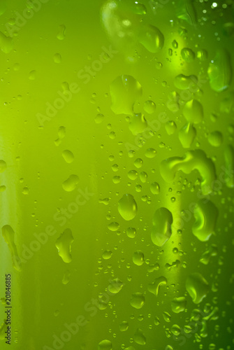 Green beer bottle with water drops isolated on white