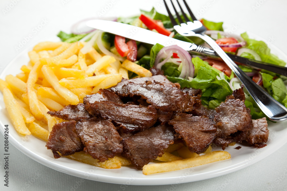 Grilled meat with fried potatoes and vegetables