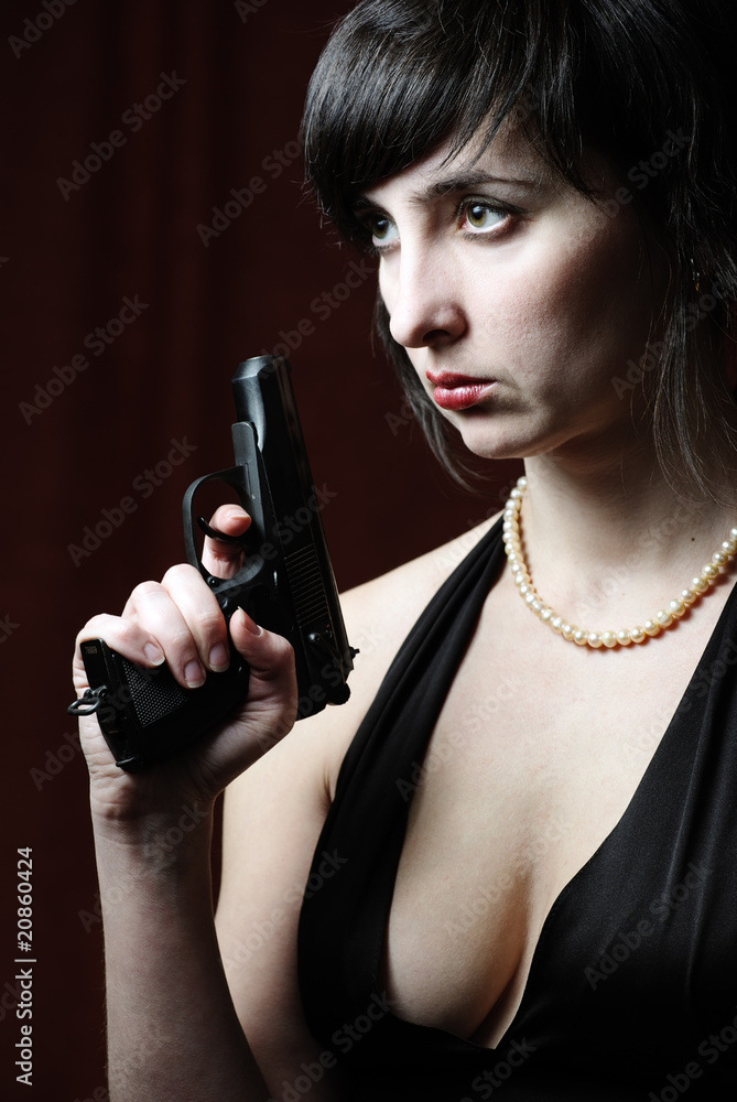 Woman in evening dress holds gun Woman in evening dress holds gun