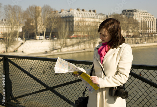 Photography Getting lost in Paris. Beautiful woman with map on a bridge