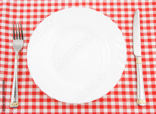 Waiting for meal  empty plate with knife and fork on tablecloth