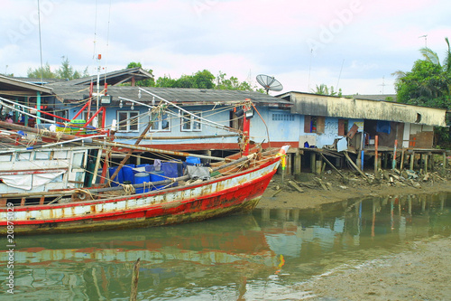 Fishermen's huts and old fishing boat in South of Thailand