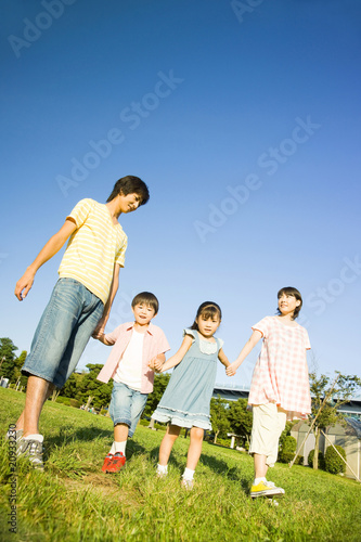 手を繋いで公園を散歩する家族