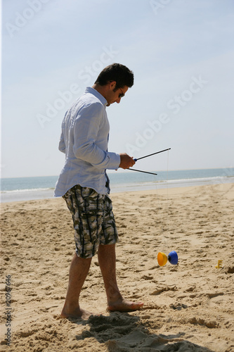 Homme jouant avec un diabolo au bord de la plage photo