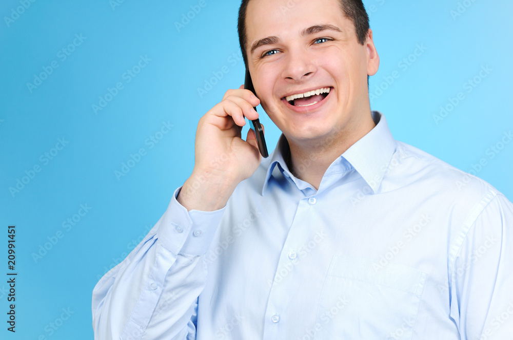 Businessman talking with cell phone on blue Businessman talking with cell phone on blue
