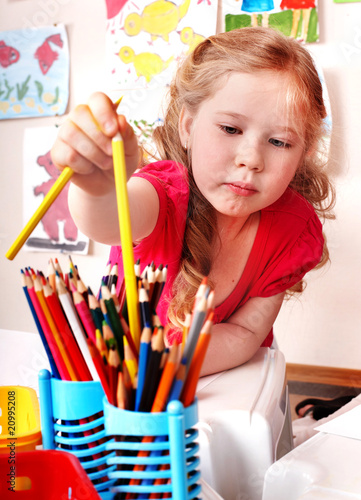 Child prescooler with  pencil in play room. photo