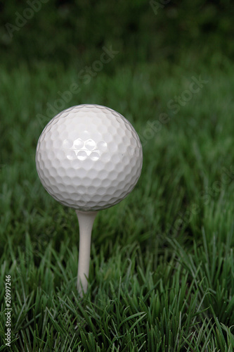 Golfball auf Tee im Gras