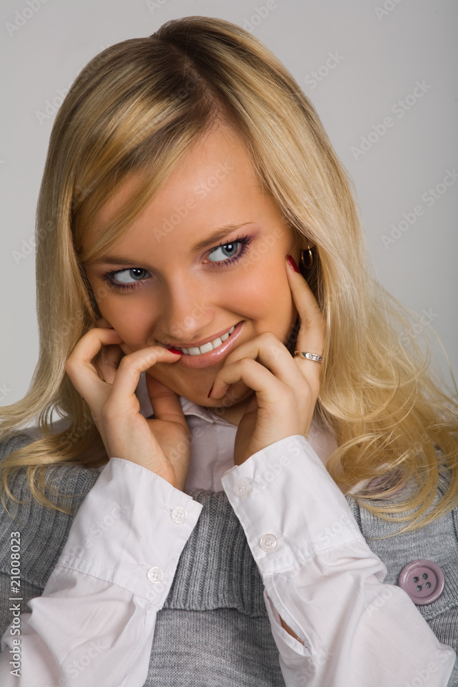 Portrait of the young beautiful smiling girl on a grey backgroun Portrait of the young beautiful smiling girl on a grey backgroun