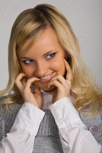 Portrait of the young beautiful smiling girl on a grey backgroun