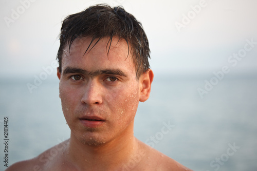 Portrait of man come up from water, on background of sea and sky