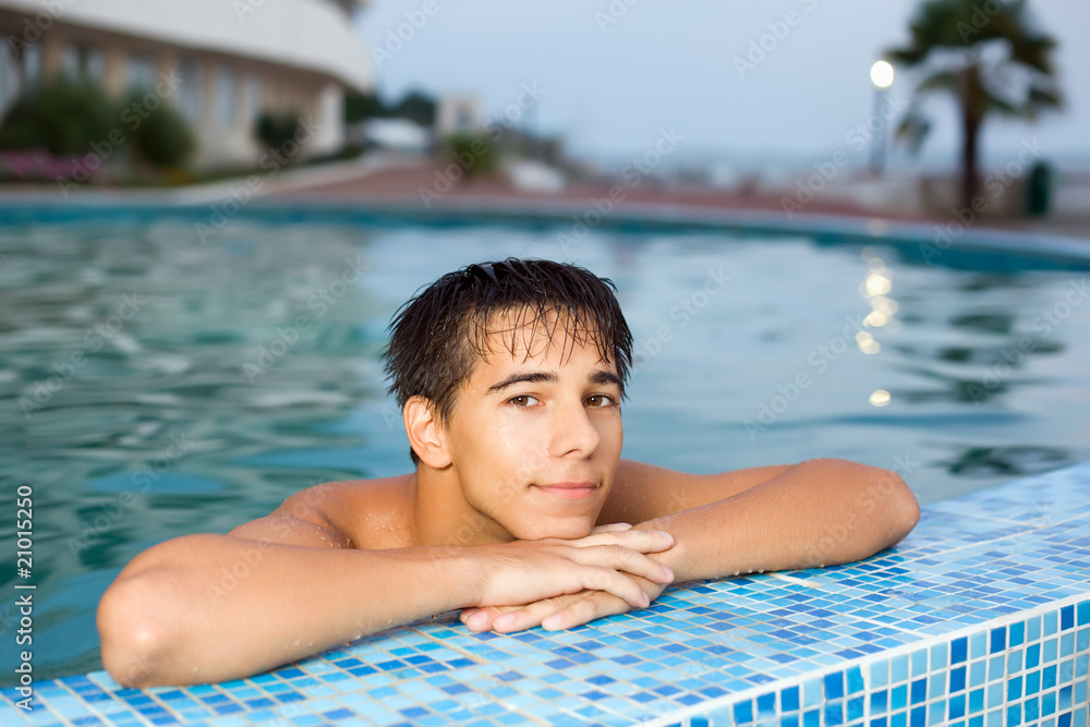 teenager boy relaxing near ledge in pool open-air Stock Photo | Adobe Stock