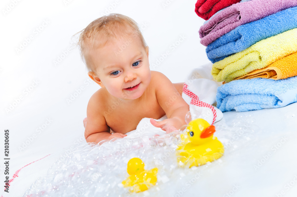 little boy playing with ducks and bubbles next to the towels little boy playing with ducks and bubbles next to the towels