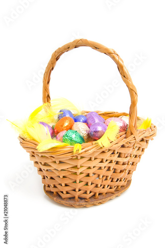 cane basket with easter eggs over white background