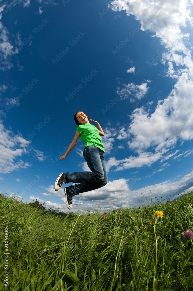 Girl jumping, running against blue sky