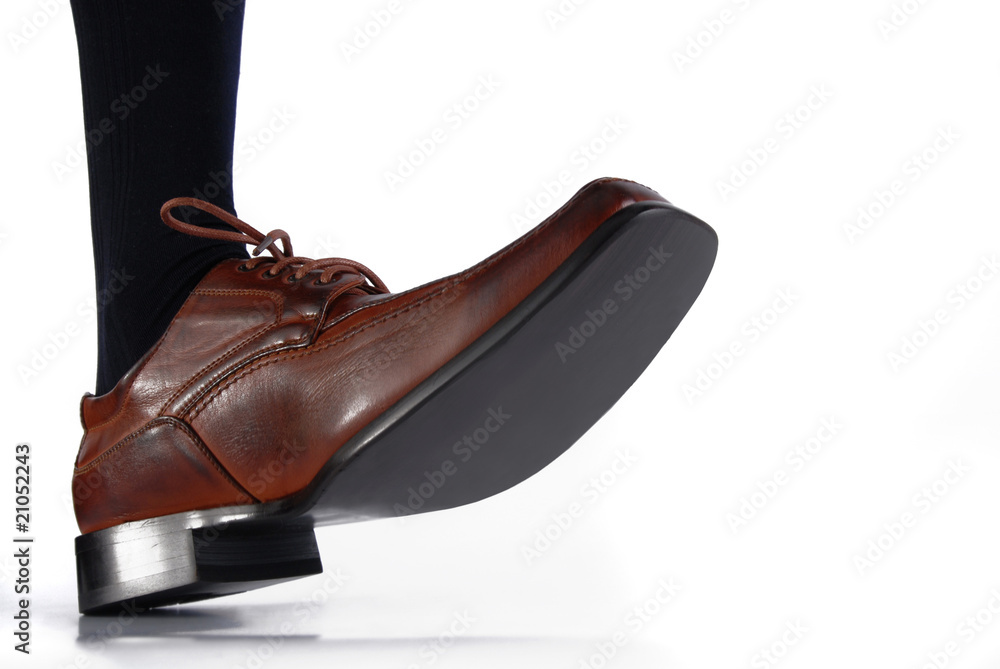 Close-up of male shoe stepping on white background Close-up of male shoe stepping on white background