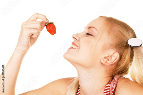 Beautiful girl tasting a strawberry