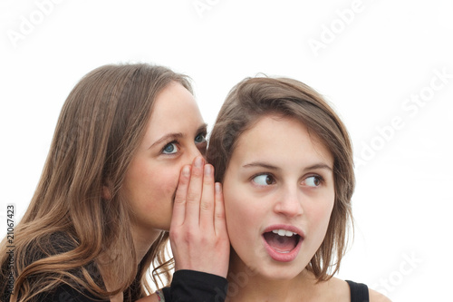 Two attractive girls gossiping isolated on white background