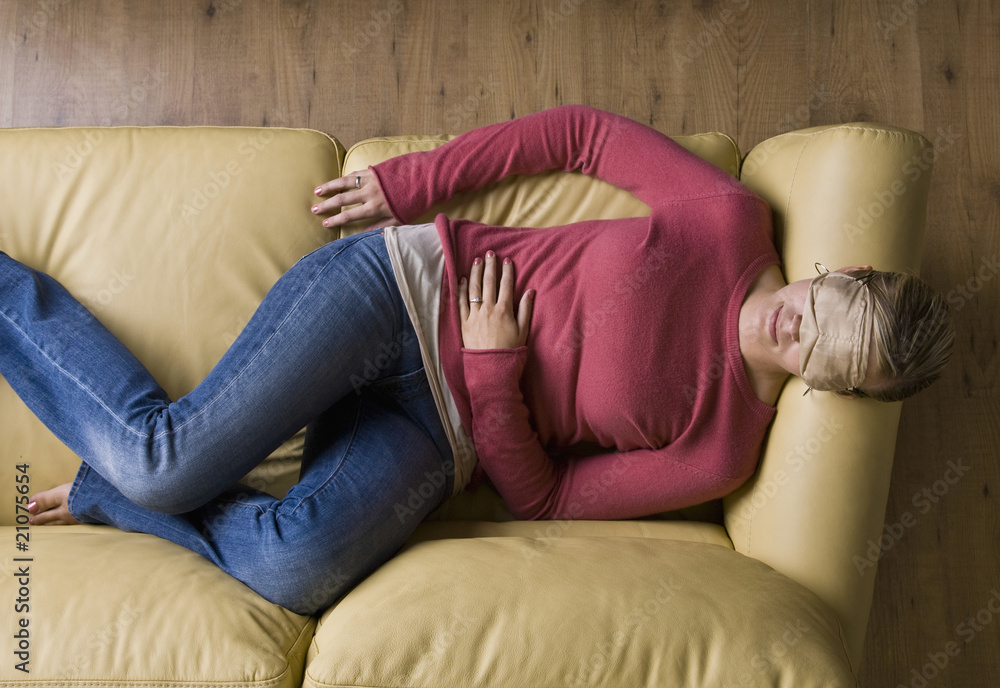 Woman laying on sofa wearing sleep mask Woman laying on sofa wearing sleep mask