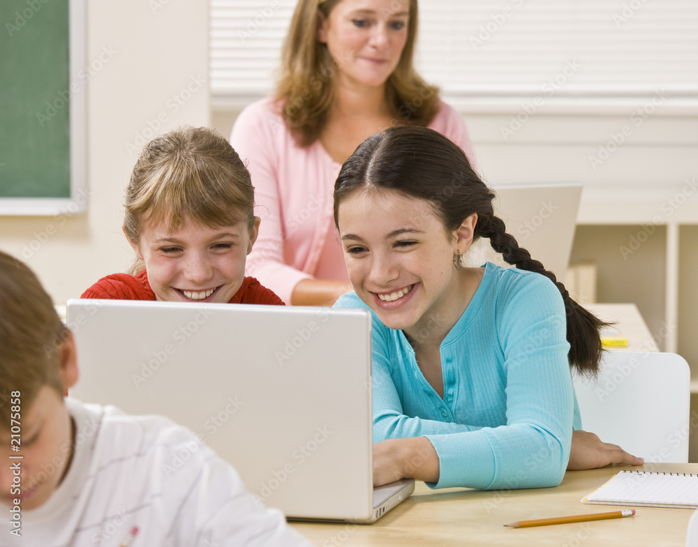 Girls using laptop in classroom Girls using laptop in classroom