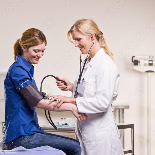 Doctor checking woman blood pressure