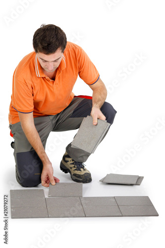 Fotografia Ouvrier posant du carrelage sur fond blanc