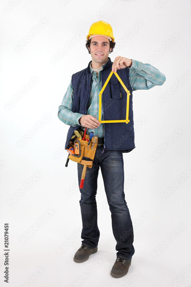 Ouvrier avec un mètre pliant à la main Ouvrier avec un mètre pliant à la main
