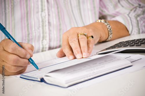 Senior woman writing checks photo