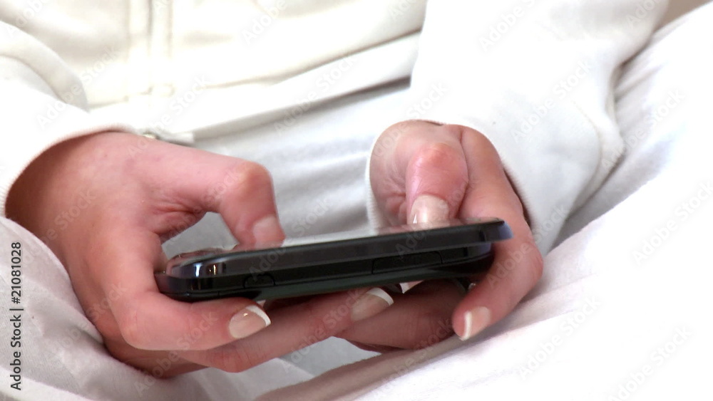 Zoom on hands sending a text message with a cellphone Zoom on hands sending a text message with a cellphone