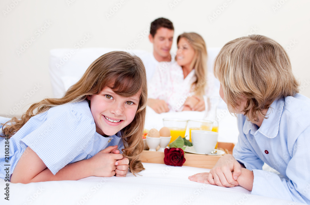 Merry family having breakfast sitting on bed Merry family having breakfast sitting on bed