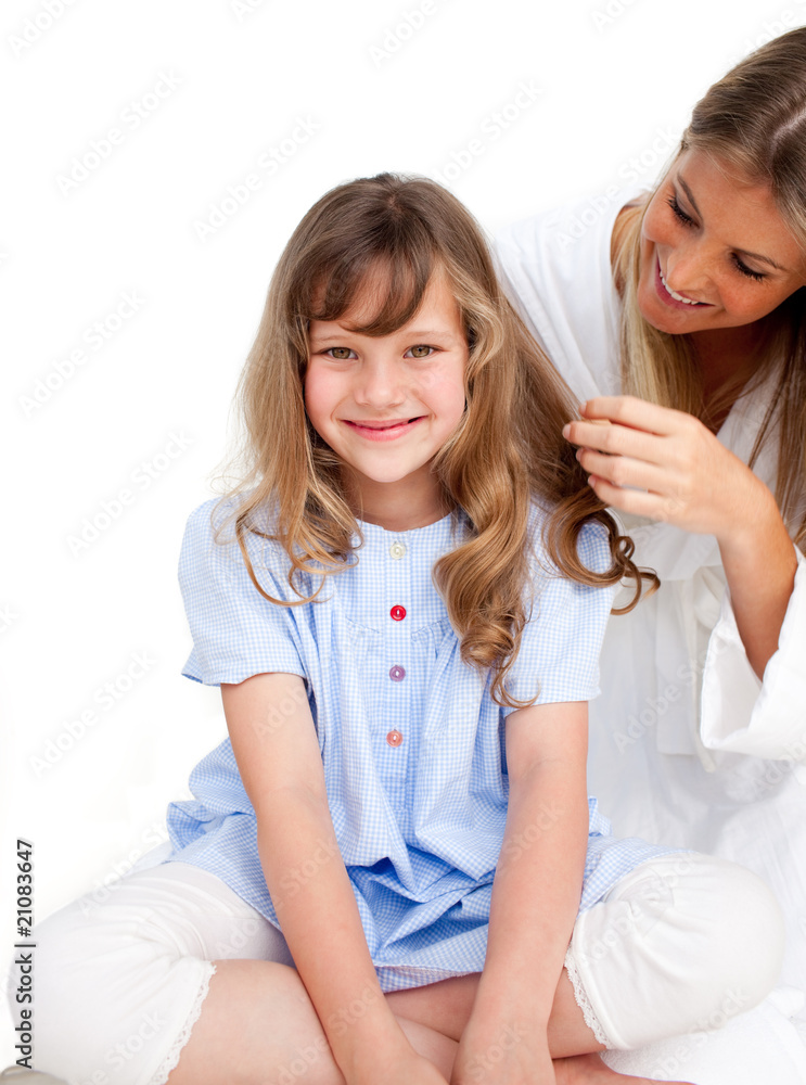 Pretty woman brushing her daugther's hair Pretty woman brushing her daugther's hair