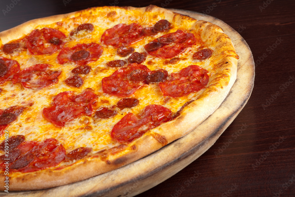 Pepperoni pizza on a wooden plate