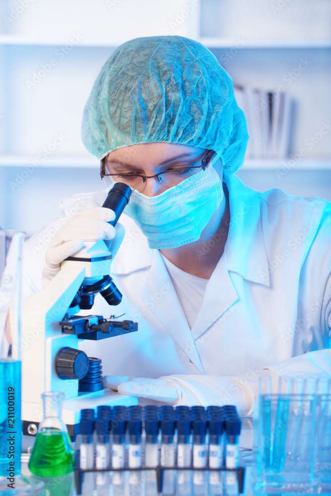Scientific researcher using a microscope in a laboratory Scientific researcher using a microscope in a laboratory