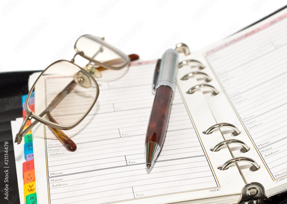 Pen and eyeglasses on agenda page Pen and eyeglasses on agenda page