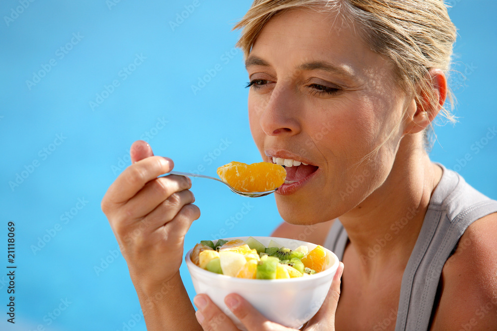 Portrait d'une femme mangeant une salade de fruit Portrait d'une femme mangeant une salade de fruit