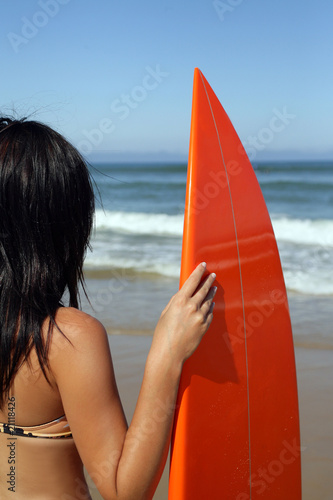 Femme à la mer avec planche de surf