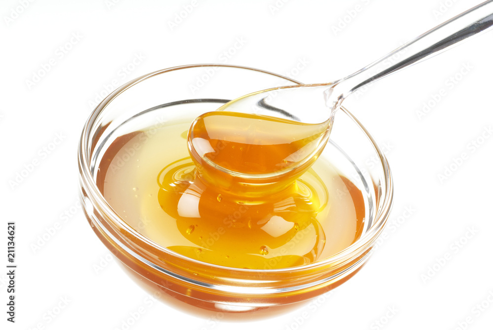 Glasschale mit Honig und Löffel