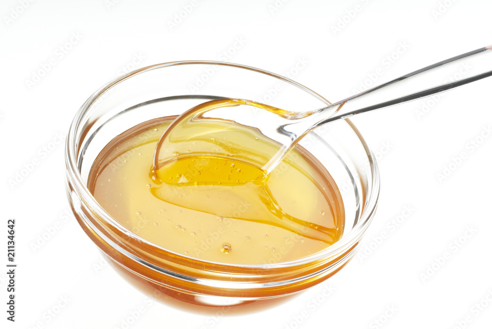 Glasschale mit Honig und Löffel Glasschale mit Honig und Löffel