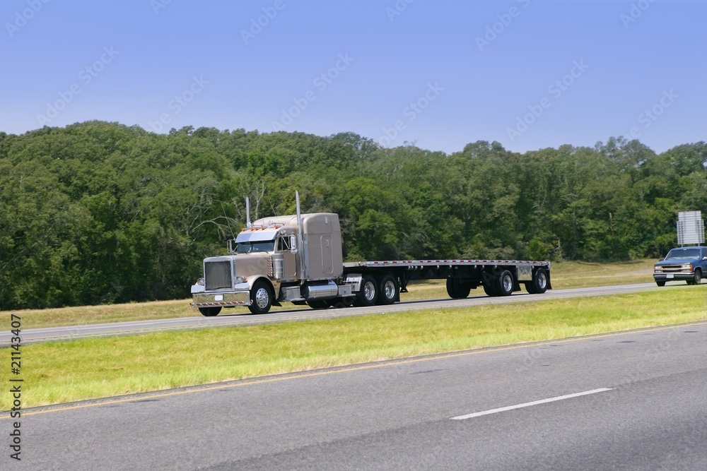 American Truck driving on a road with green forest