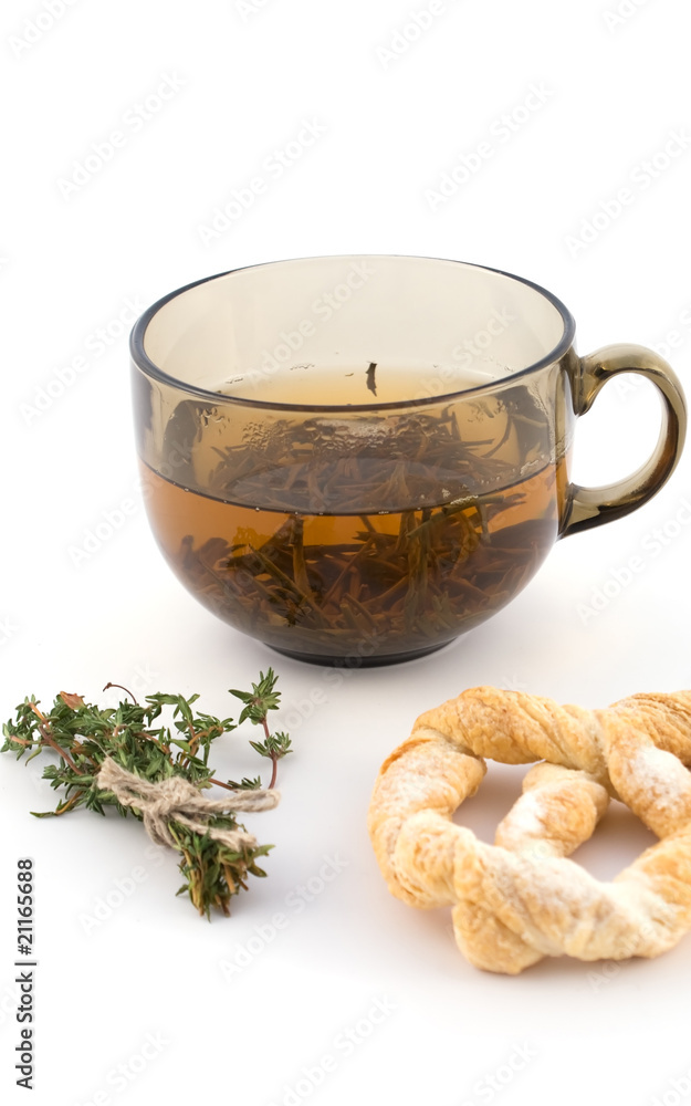 Fototapeta premium Cup of green tea with a bundle of herbs and bagel